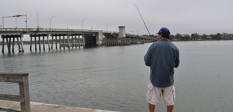 Despite the foggy weather and a bit of mist, Tin Truong fishes out at Bay Island Park.