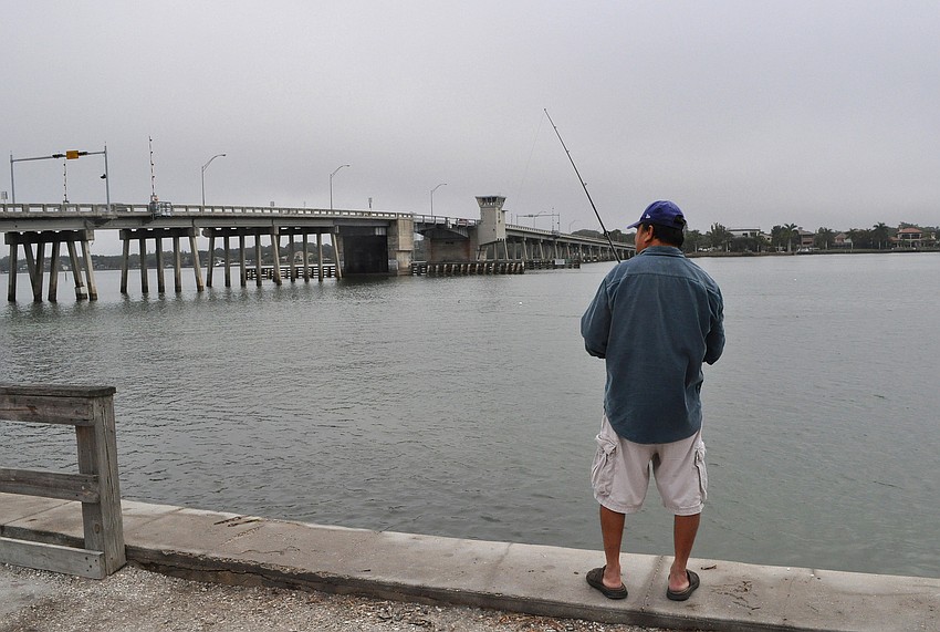 Despite the foggy weather and a bit of mist, Tin Truong fishes out at Bay Island Park.