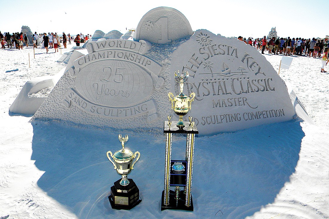 Trophies for the winners stand in front of the group carving of the event logos. Photos by Norman Schimmel