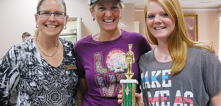 Temple Emanu-El Sisterhood President Laura Zalkin, left, presented the Savory Kugel trophy to Kala and Kendal Sheckler.