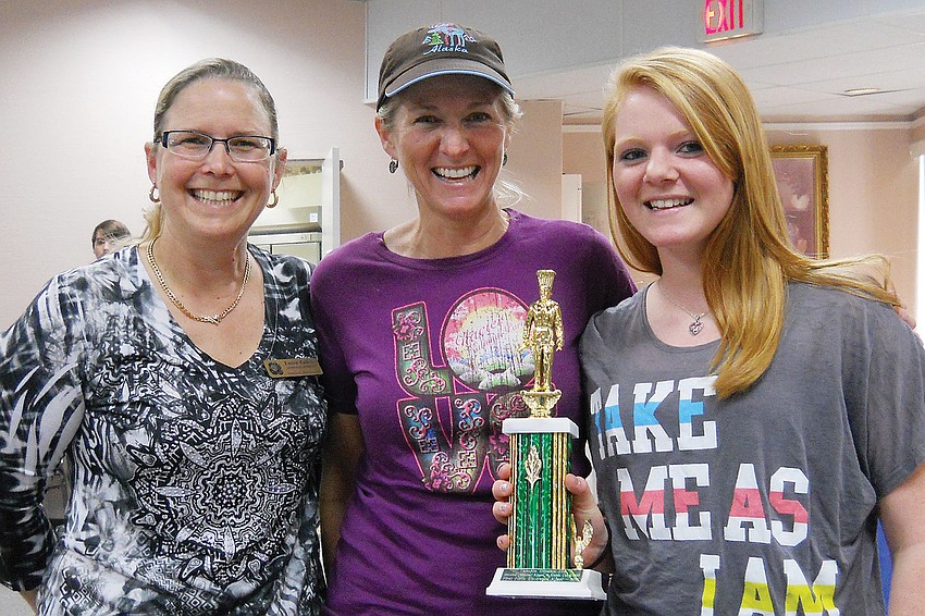 Temple Emanu-El Sisterhood President Laura Zalkin, left, presented the Savory Kugel trophy to Kala and Kendal Sheckler.
