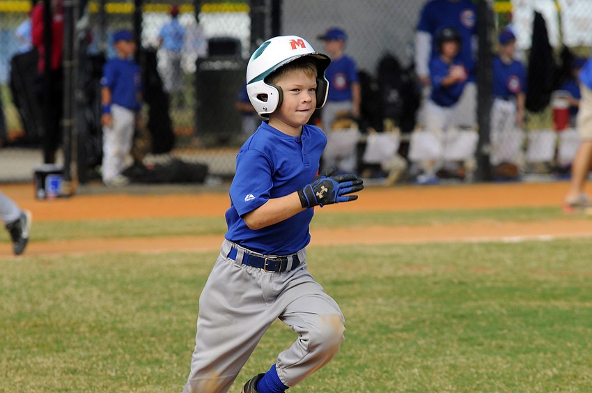 Alex Heintz races down the first base line during the Rookies division championship game.