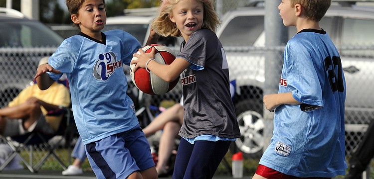 Eight-year-old Jason Jessup, left, and James Crain, 7, race to double-team Kayla Cummings, 8.
