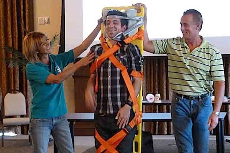 Lakewood Ranch CERT Paramedic Nina McCabe and Manatee County Paramedic Lt. Dave Byington, right, demonstrate backboard procedures for neck and back injuries on new CERT member Robert McCabe, center. Courtesy photo.