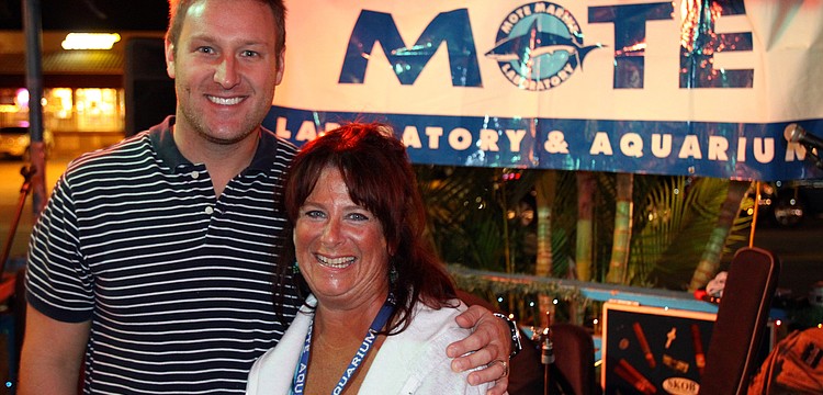 Ryan Schmidt, general manager, and Pamela Siderski, volunteer at Mote, pose together in front of the Mote sign, Friday, Dec. 2 at Siesta Key Oyster Bar.