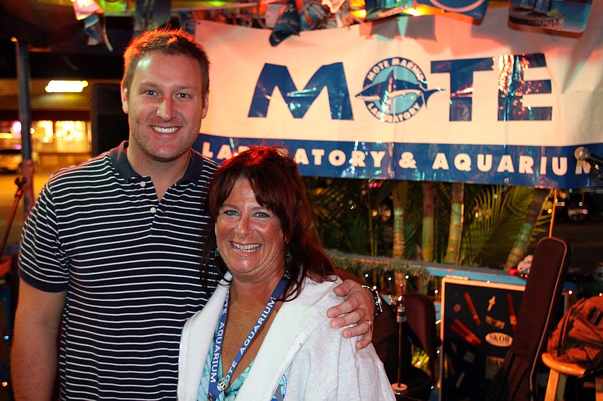 Ryan Schmidt, general manager, and Pamela Siderski, volunteer at Mote, pose together in front of the Mote sign, Friday, Dec. 2 at Siesta Key Oyster Bar.