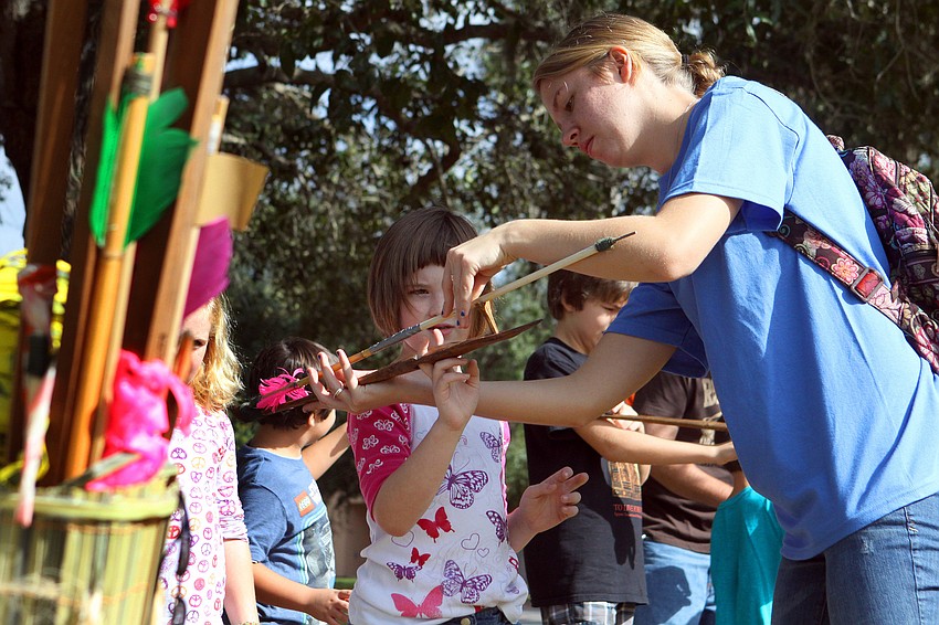 Charlotte Jaffe, 8, gets some help with the atlatl from Jessie Ploss, Saturday, Dec. 3, during Fruitville Elementary's junior archaeology day at New College's Public Archaeology Lab.