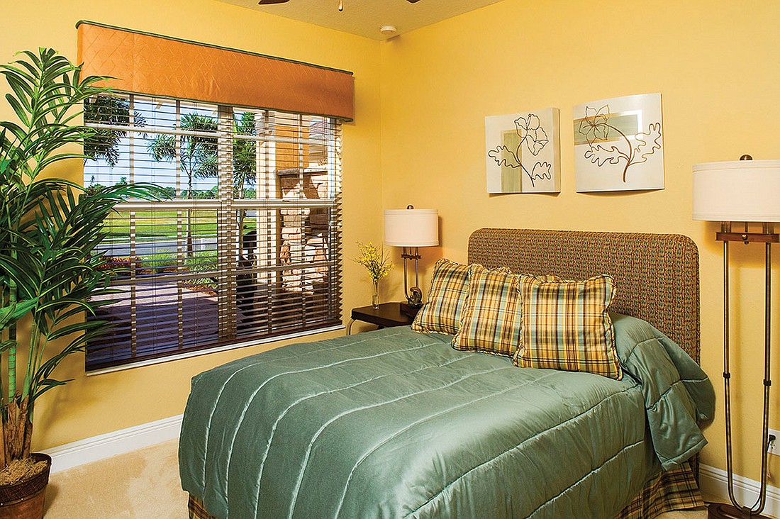 The color scheme in the guest bedroom is the reverse of the master bedroom, with a teal-colored bedspread and a textured woven upholstered headboard, which features teal and brick colors.  Photos courtesy of The Greg Wilson Group.