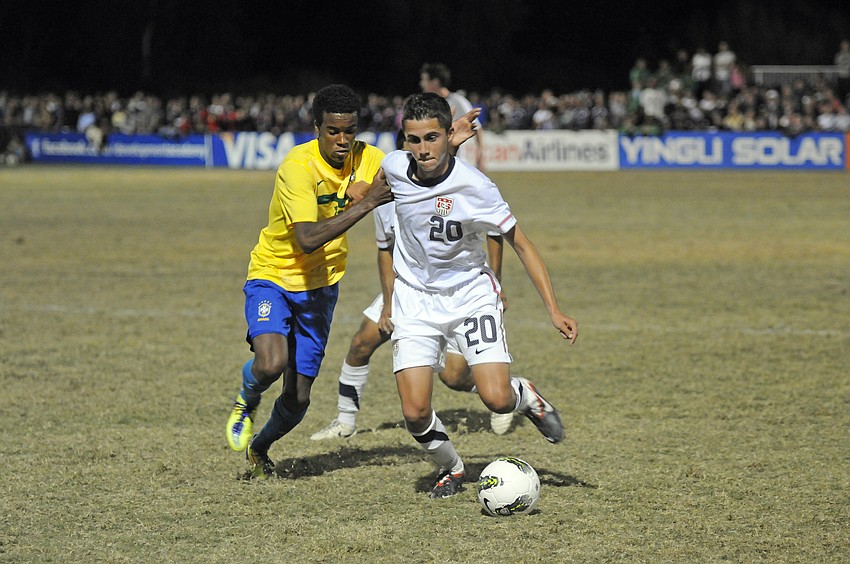 Midfielder Christopher Lema attempts to dribble past a Brazilian defender.