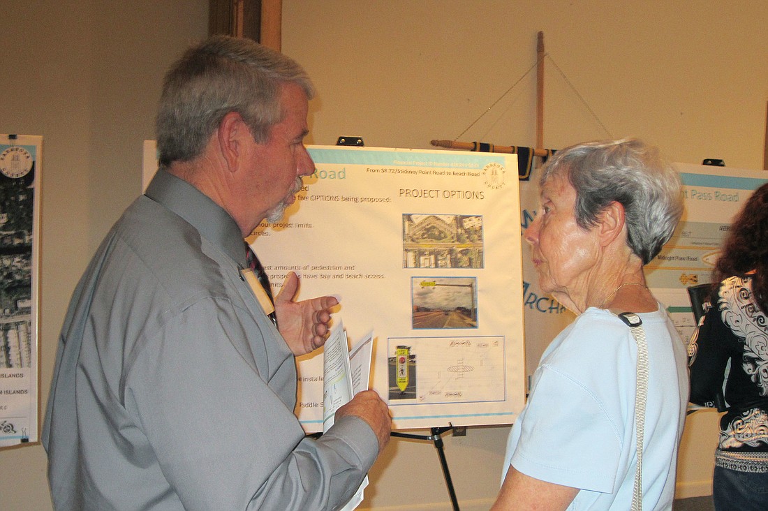 Gary Amig, access management/safety program manager for District One of the Florida Department of Transportation, talks Tuesday evening with Kathy Bell, a resident of the Excelsior condominium complex.