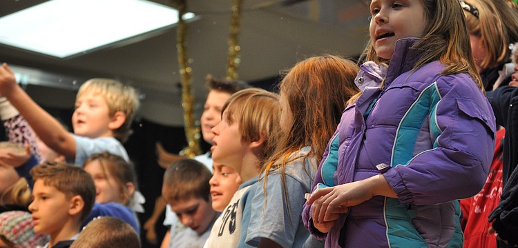 Julianna Cunningham, right, stayed focused on singing, even as her classmates turned to catch falling snow.