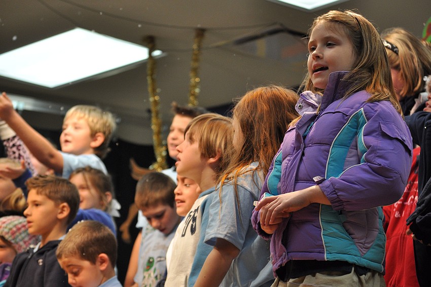 Julianna Cunningham, right, stayed focused on singing, even as her classmates turned to catch falling snow.