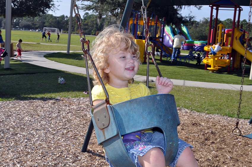 Two-year-old Olivia Miller had a blast swinging on the swings.