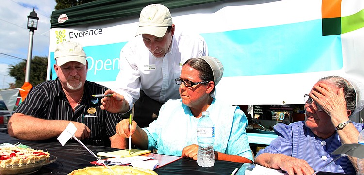 The judges try and figure out what pie will get first place in the fruit pie category, during the 1st annual pie contest, Friday, Dec. 9 at Everence Federal Credit Union.