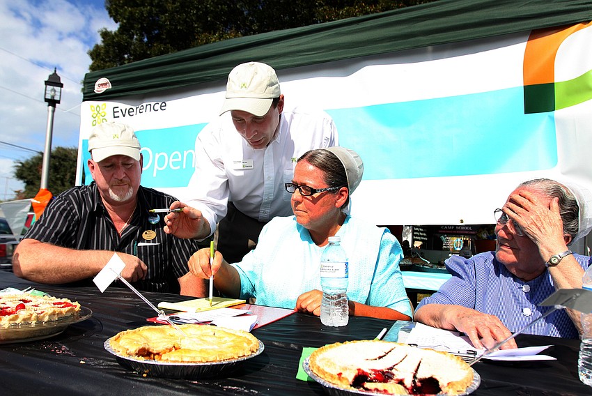 The judges try and figure out what pie will get first place in the fruit pie category, during the 1st annual pie contest, Friday, Dec. 9 at Everence Federal Credit Union.
