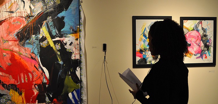 Indiana Martinez listens and looks at a piece done by Tim Jaeger.