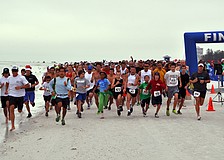 The runners for the 5K start off running down the beach, Saturday, Dec. 10, for the 35th annual Sandy Claws run on Siesta Key Beach.