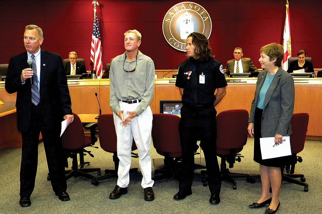 Interim County Administrator Terry Lewis recognizes Sarasota County lifeguards Scott Ruberg and Robert Martini as County Commission Chairwoman Nora Patterson looks on. Photo by Norman Schimmel.