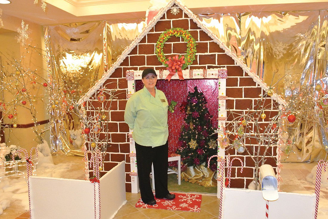 Deborah Kushlan stands in front of her 8-foot-tall gingerbread masterpiece. Photo by Loren Mayo.