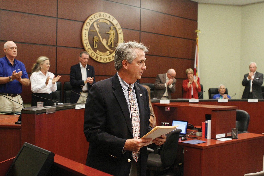 Town Manager Bruce St. Denis exits the Longboat Key Town Commission Chambers Monday, Sept. 19, during a standing ovation for his 14 years of service to the town. Photo by Rachel S. O'Hara.