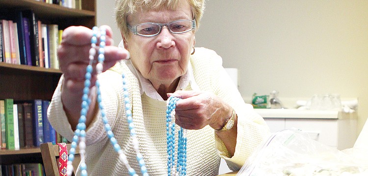 Virginia Tangeman sorts rosaries she made in February at St. Mary, Star of the Sea, Catholic Church.