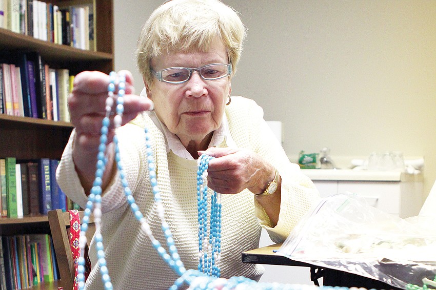 Virginia Tangeman sorts rosaries she made in February at St. Mary, Star of the Sea, Catholic Church.