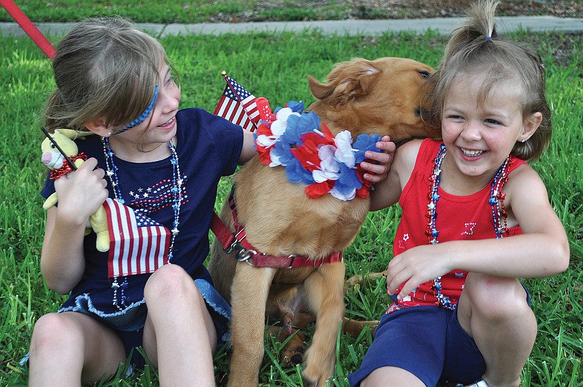 Noelle and Heather Amorini play with their dog, Tucker, in July at the Longboat Key Freedom Fest celebration.