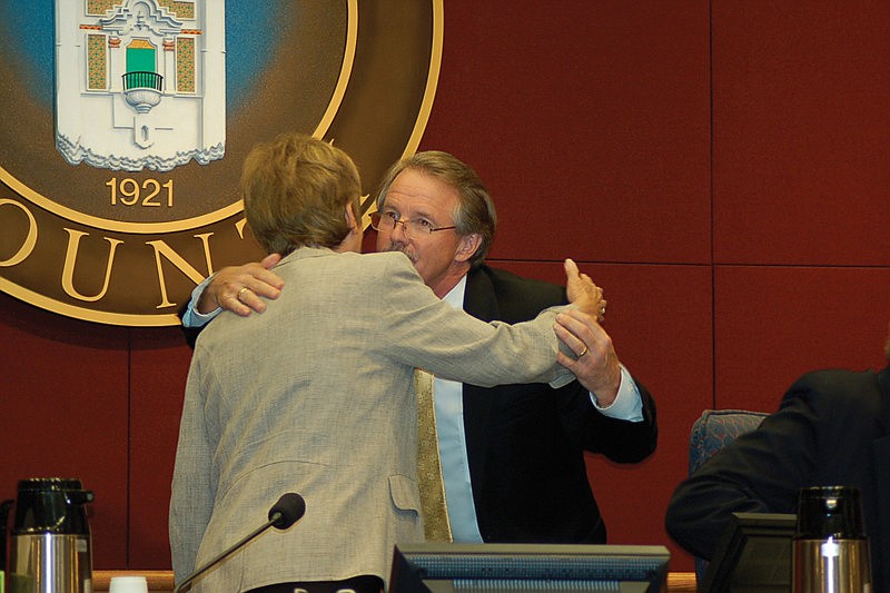Before he walked away from the commission table mid-meeting May 25, Jim Ley shook hands and hugged all five county commissioners, including Chairwoman Nora Patterson. Photo by Robin Roy.