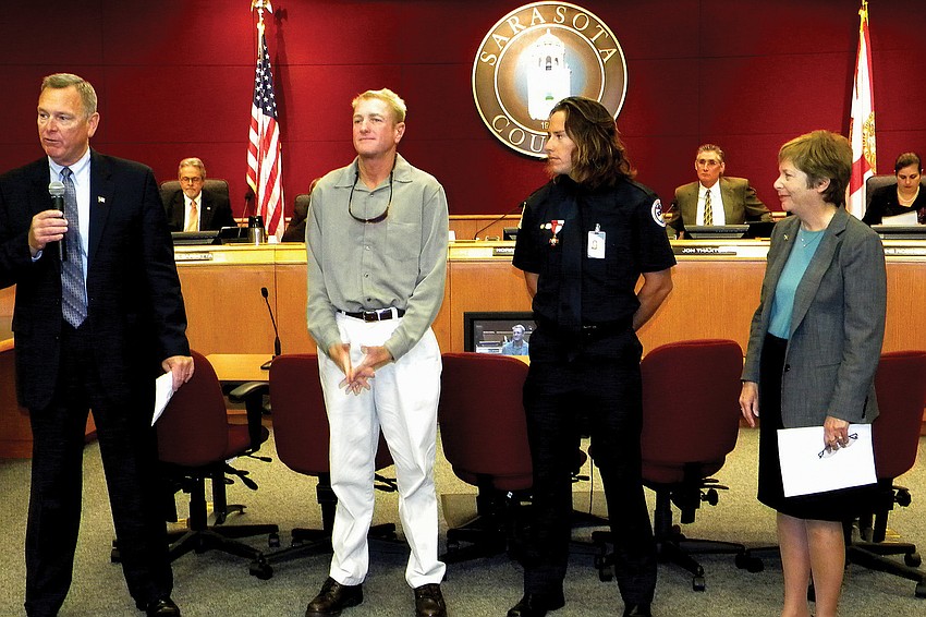 Interim County Administrator Terry Lewis and Commission Chairwoman Nora Patterson recognized lifeguards Scott Ruberg and Robert Martini for recovering the wallet of a grateful Canadian tourist.