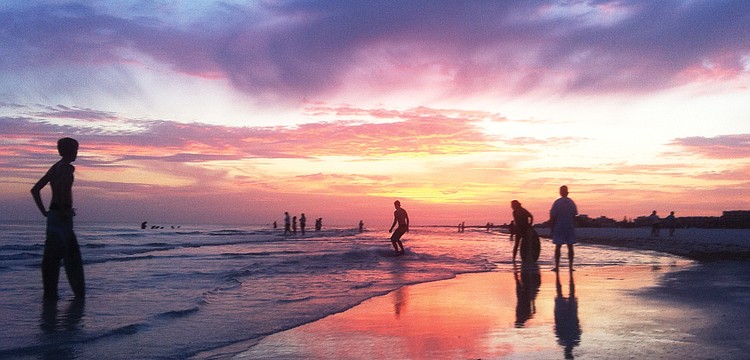 SKIMMING THE SURFACE: Gulf Gate resident Stewart Green took this photo of skimboarders at sunset on Siesta Key Beach.