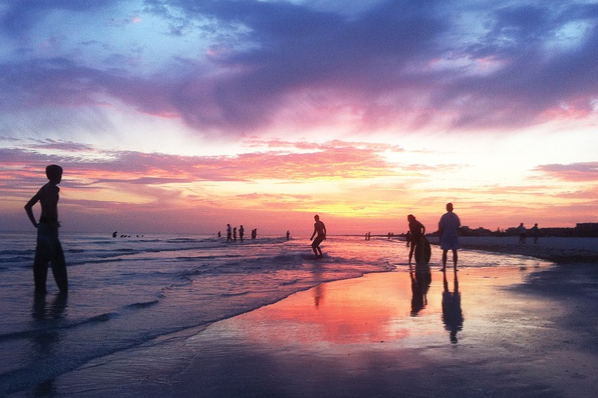 SKIMMING THE SURFACE: Gulf Gate resident Stewart Green took this photo of skimboarders at sunset on Siesta Key Beach.