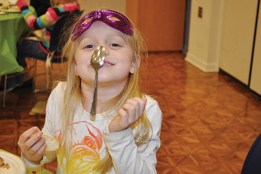 Riley Putnam practices her spoon-sticking ability in January at a Church of the Redeemer dinner.