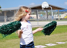 Cameron Seguin cheers on her big sister by waving pom-poms in the air at Tatum Ridge Elementaryâ€™s March jog-a-thon.