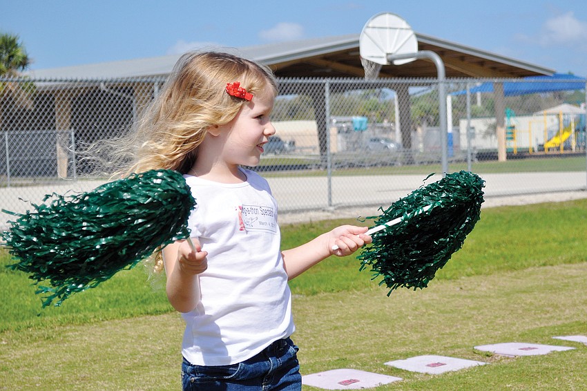 Cameron Seguin cheers on her big sister by waving pom-poms in the air at Tatum Ridge Elementaryâ€™s March jog-a-thon.