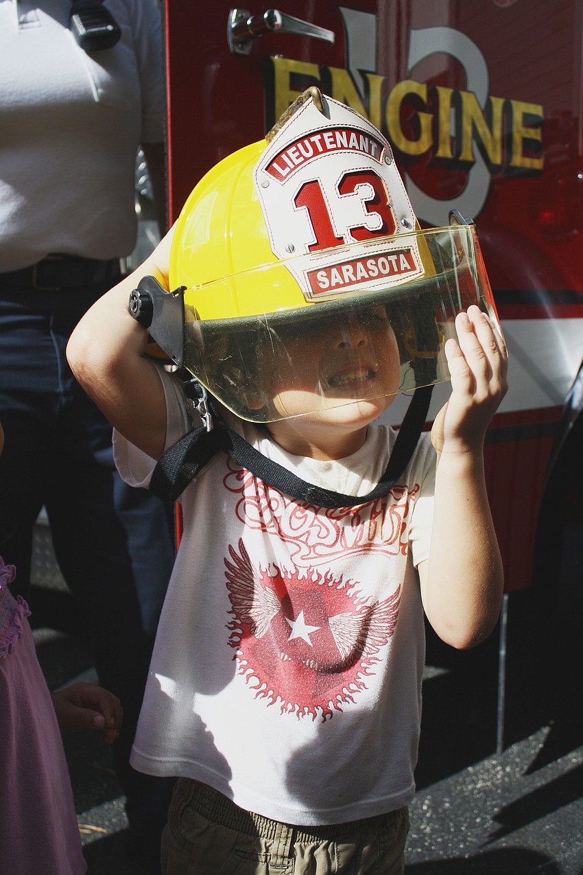 Liam Lizotte struggles to keep the fire hat on his head. It is just too heavy.