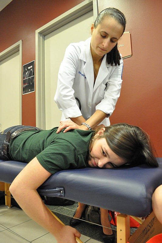 Lake Erie College of Osteopathic Medicine medical student Samantha Mousset works on Maddie Schroer.