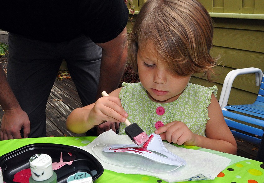 Charleigh Bruss-Schulz, 3, combined pink and red paints for her mask.
