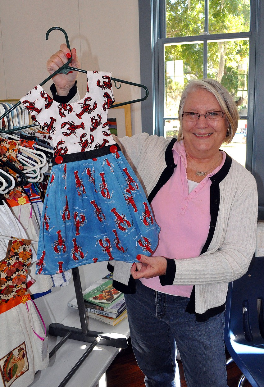 Shelly Campbell shows off one of her favorite tea towels she sold at Pioneer Day.