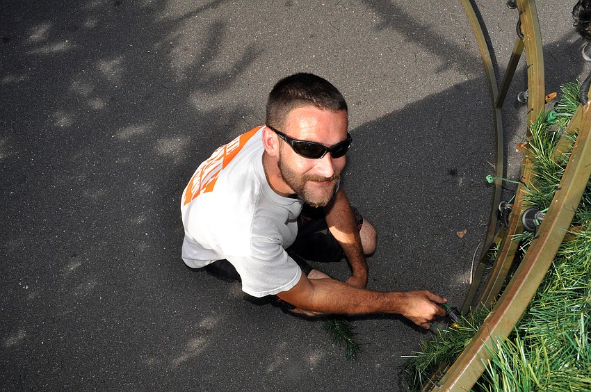 Josh Trevino works on some of the lighting and wiring from inside the tree.
