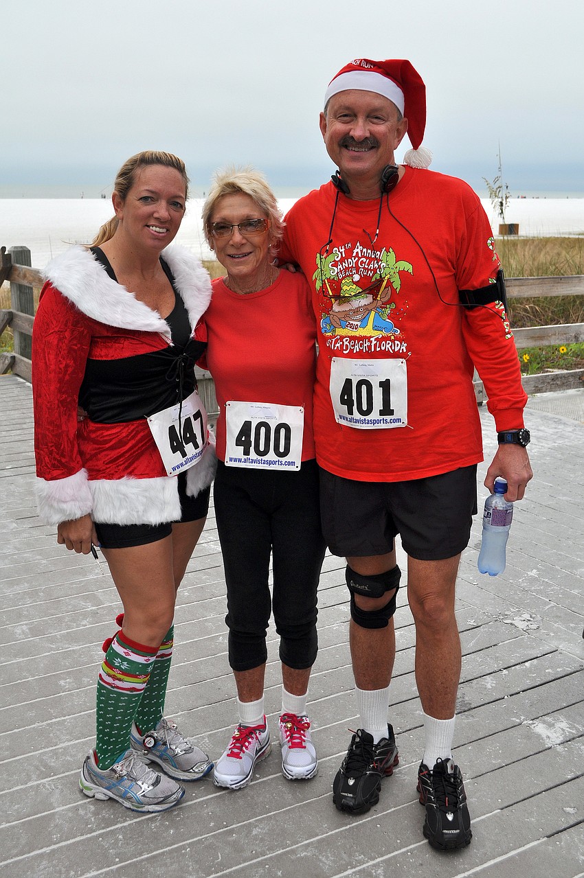 Laurie Nelson poses with Anne and Gus Lorberg Saturday, Dec. 10, before running in the 35th annual Sandy Claws run on Siesta Key Beach.