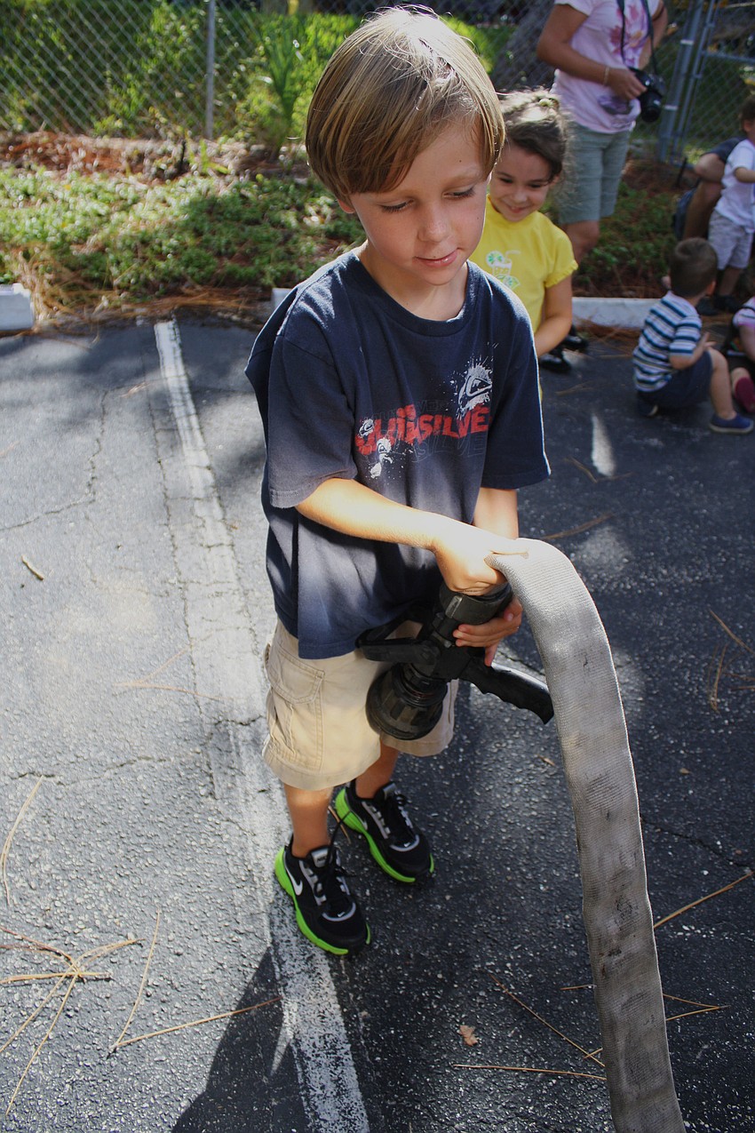 Sean MacFarlane investigates the truckâ€™s hose. â€œItâ€™s heavy,â€ he said.