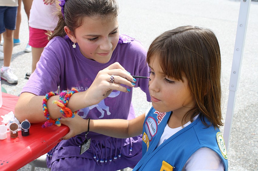 Twelve-year-old Emaleigh Ralsten has been a Girl Scout for nine years. Her troop is made up of home-schooled girls, who run a face-painting tent at the event. Haley Romano in her first year of Girl Scouts gets her face painted.
