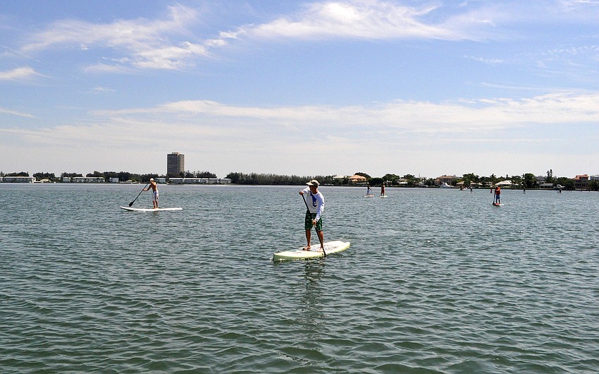 Paddlers make their way back against the wind during the poker run.