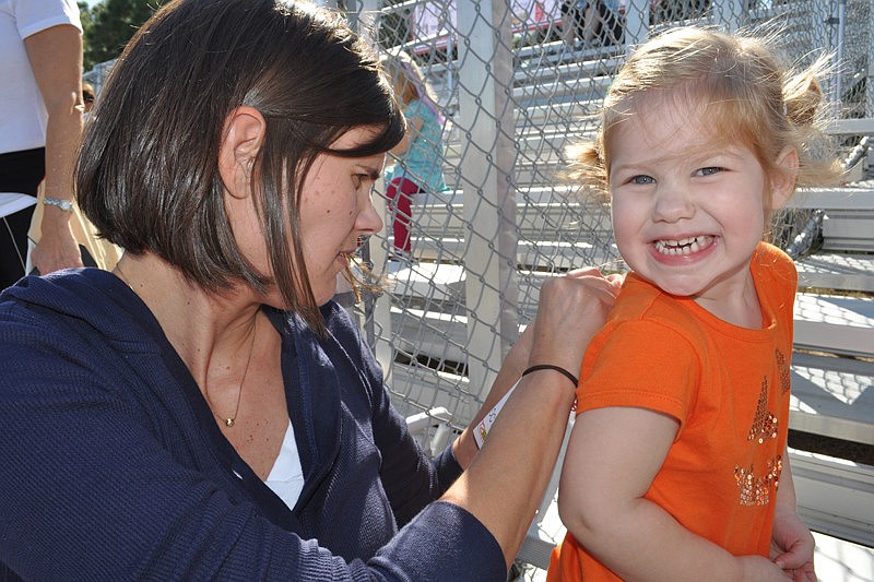 Barrington Ridge resident Kim Rupprecht pins a race number on her daughter, Carden, 2.