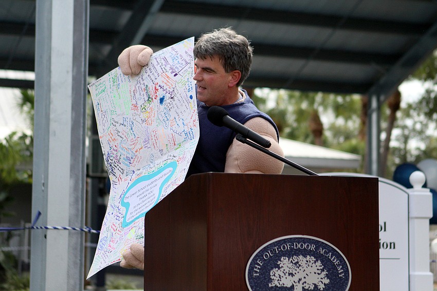 David Mahler shows off the thank you card that was signed by students and staff at Out-of-Door Academy for the Dart Family.