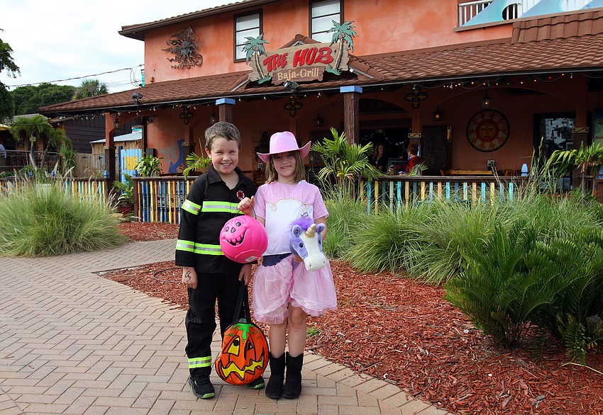 Chris Kelly, 8 and Faith Wroblewski, 8, pose outside The Hub, Monday, Oct. 31, during the Safe Kids trick-or-treating event in Siesta Key Village.