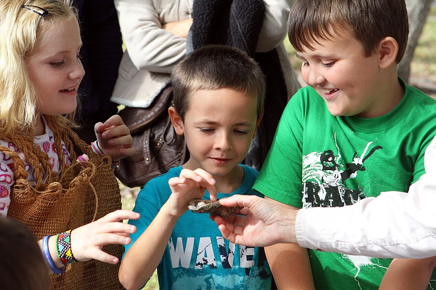 Liam Ryan, 7, touches a live oyster, Saturday, Dec. 3, during Fruitville Elementary's junior archaeology day at New College's Public Archaeology Lab.