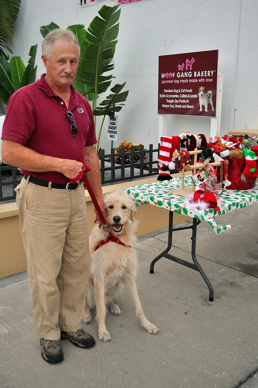 Orv Matiesh and Argus pose next to Woof Gang Bakeryâ€™s table, Friday, November 9, during Southside Stroll.