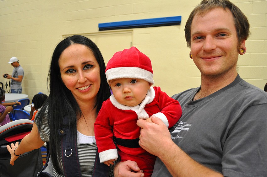 Merly, Cole, 7 mos., and Andrew Miller wait in line to get a photo with Santa.