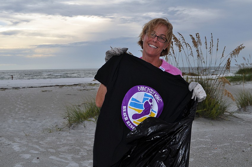 Jan Duffy shows off her free t-shirt for helping out with the Barefoot Wine Beach Cleanup Thursday, Sept. 8, at Ted Sperling Park.